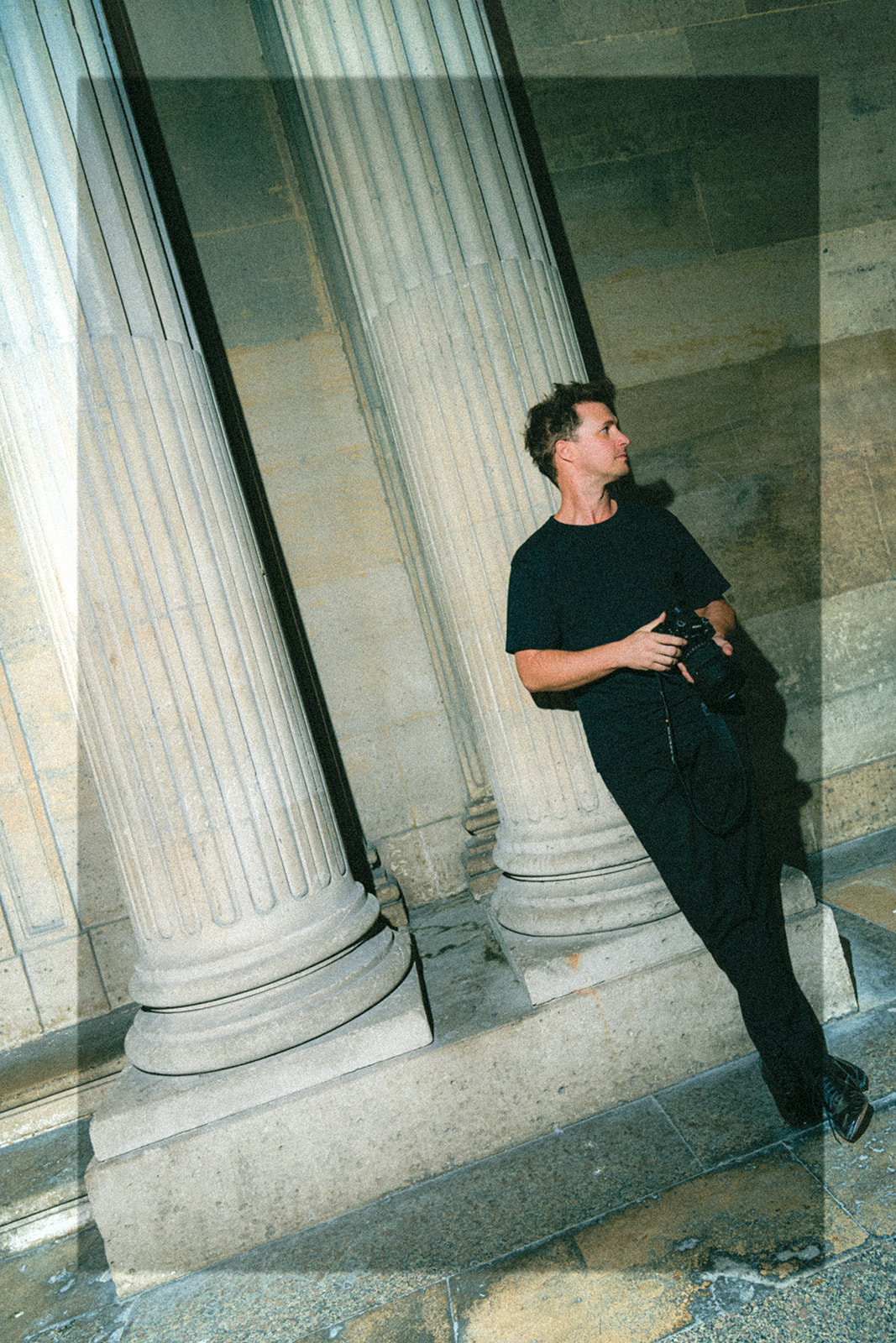 Jérémy Froeliger avec son appareil photo entre les colonnes à Paris