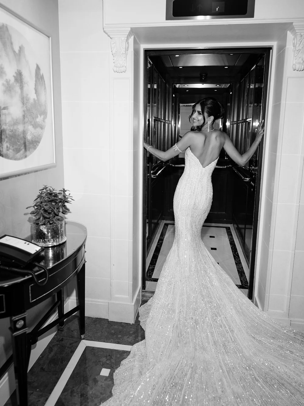 Mariée en robe couture photographiée au flash dans un ascenseur, portrait éditorial en noir et blanc
