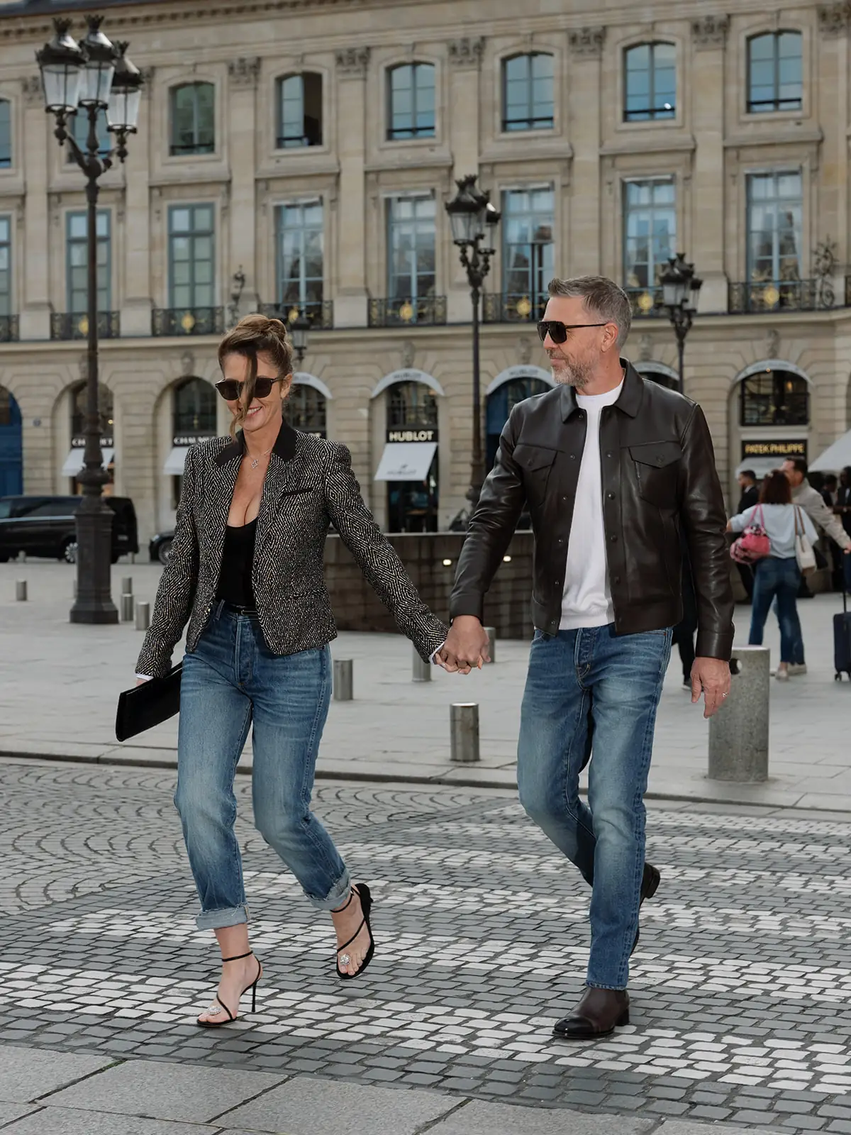 Couple walking across Place Vendôme in Tom Ford denim and jackets