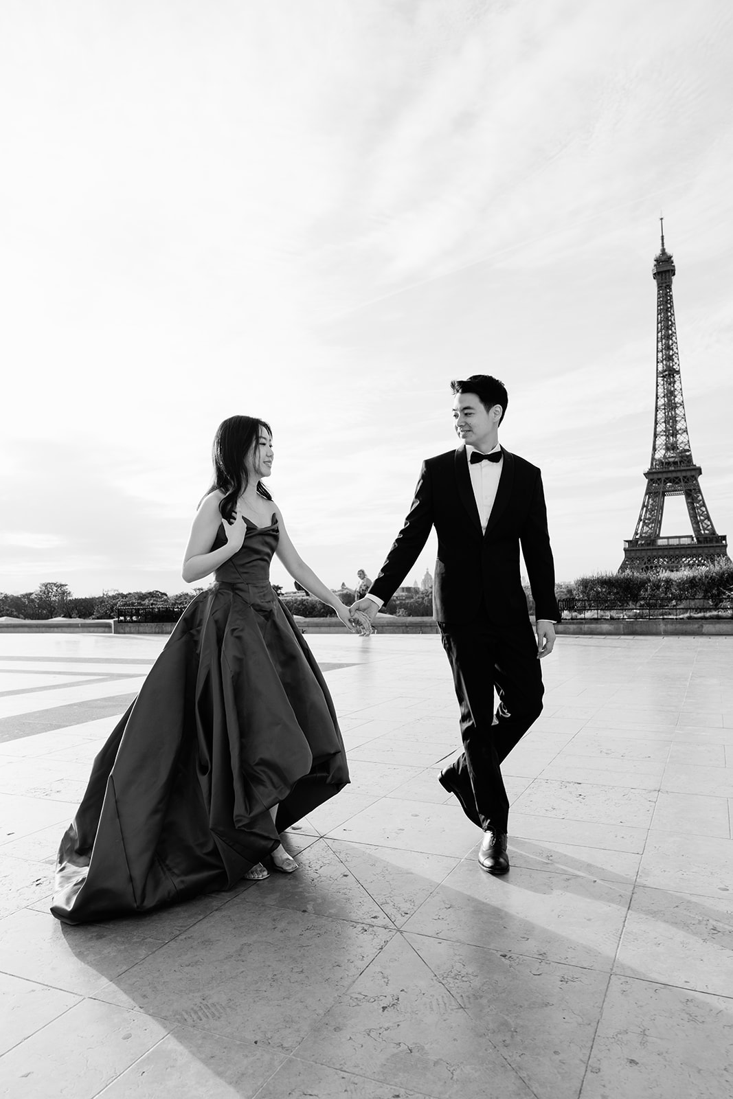 Black and white Paris pre-wedding couple walking at Trocadero with an Eiffel Tower view
