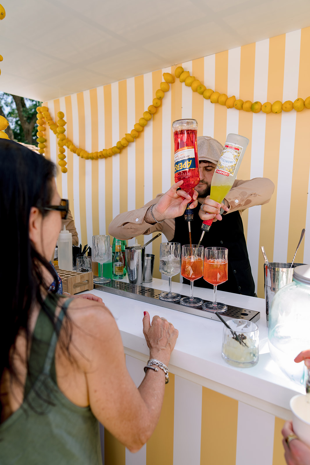 Outdoor bartender preparing Aperol and limoncello cocktails for a wedding pool party