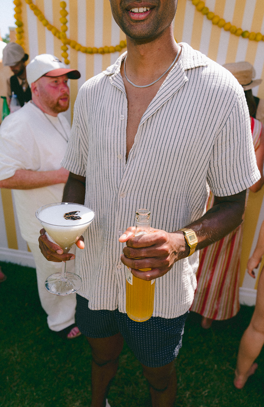 Guest holding a signature summer cocktail at a wedding pool party in France