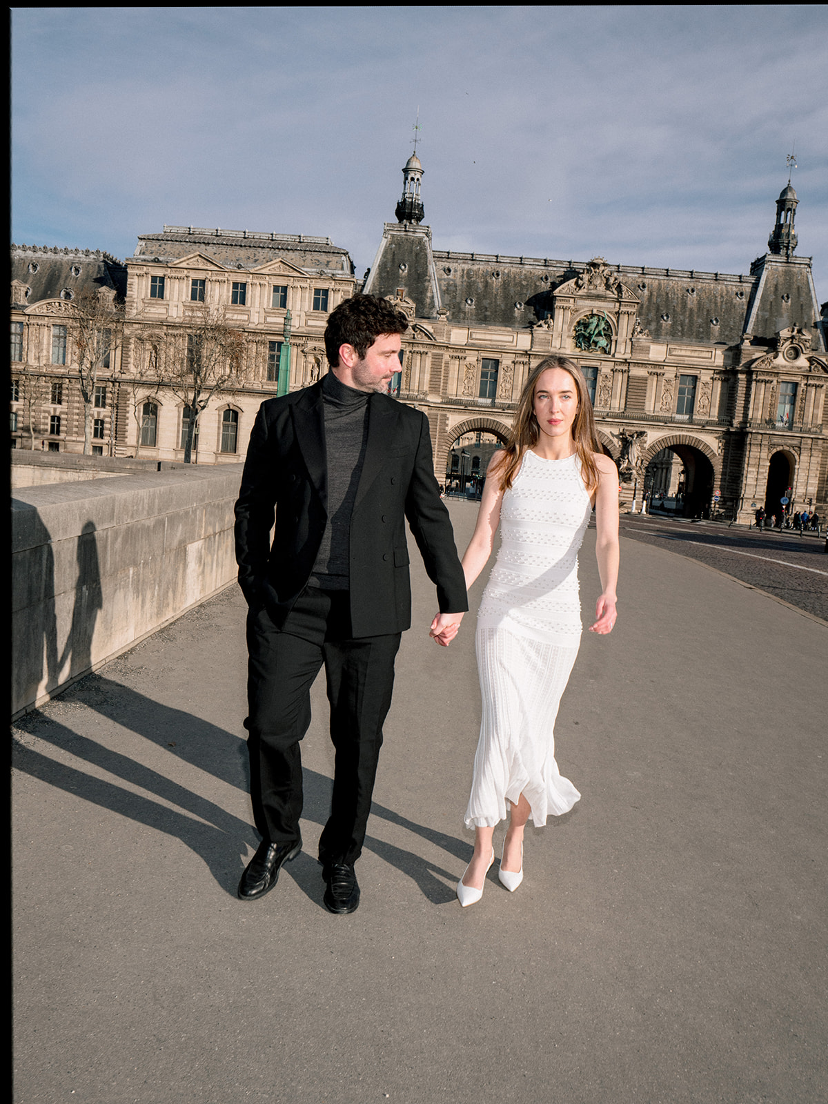 Fashion-forward couple walking at the Louvre during a modern editorial Paris session