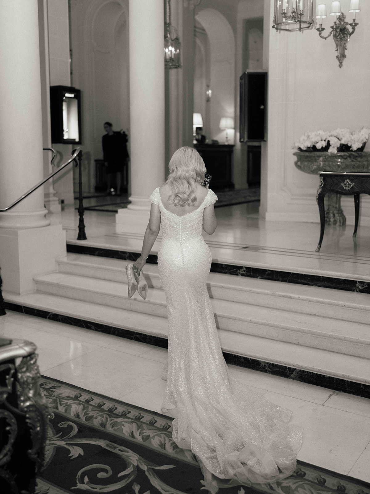 Portrait vertical de la mariée en robe perlée dans un intérieur parisien