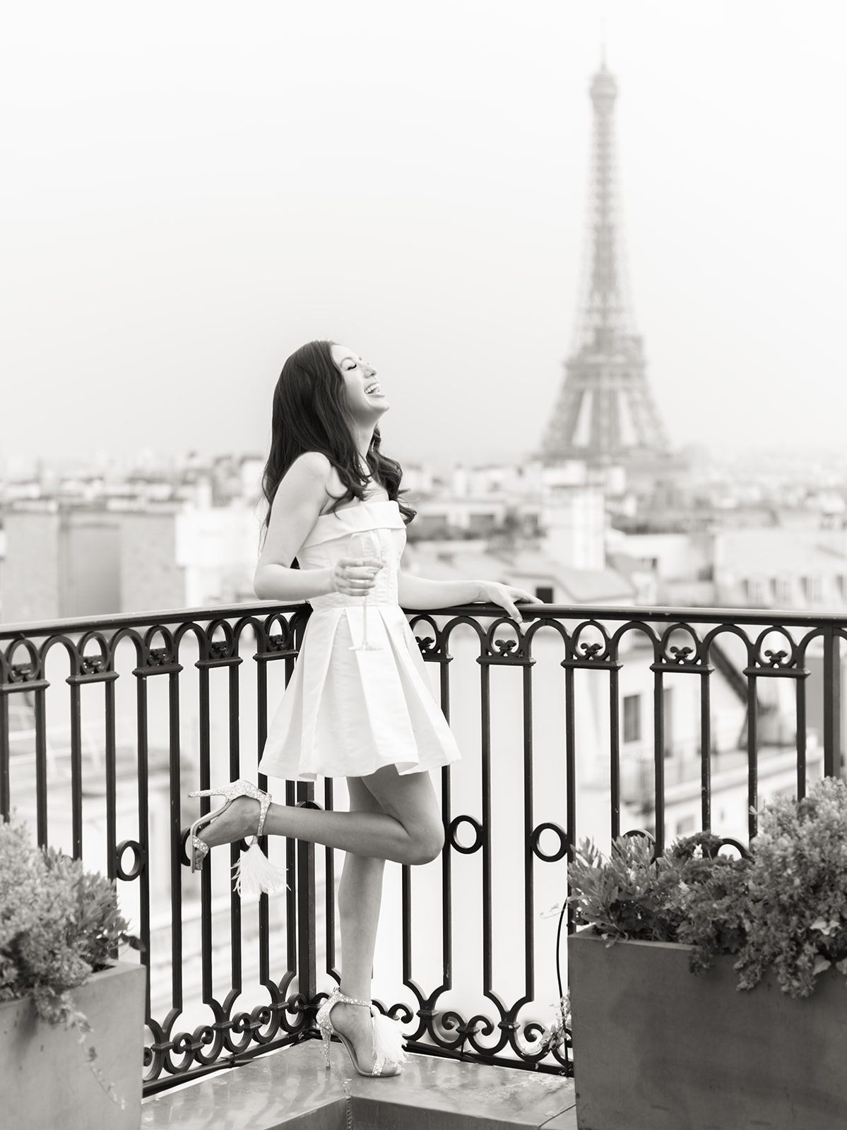Bride on a terrace at The Peninsula Paris with the Eiffel Tower behind her