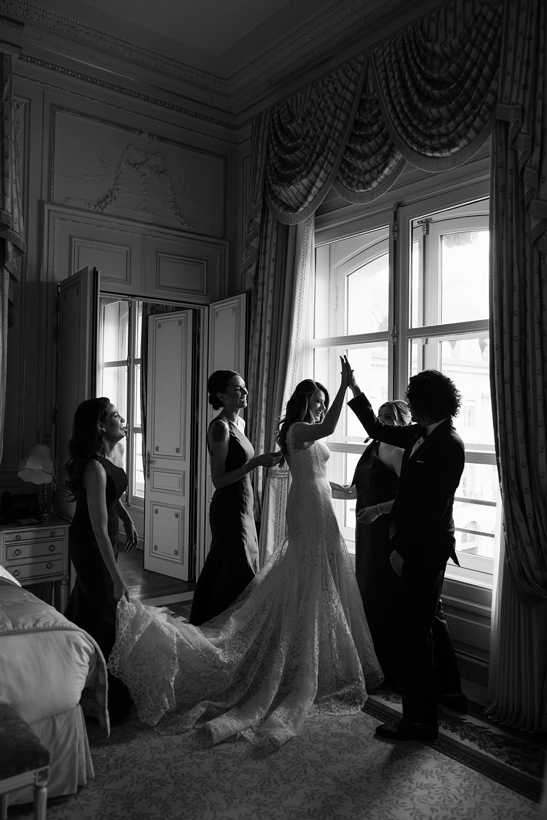 Bride preparing her wedding dress in window light at the Ritz Paris