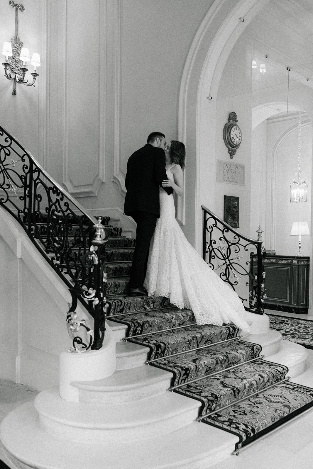 Black-and-white portrait of the bride and groom on the Ritz Paris staircase