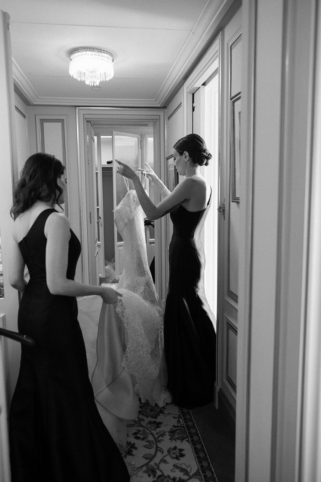 Black-and-white photograph of the bride having her wedding dress fitted at the Ritz Paris