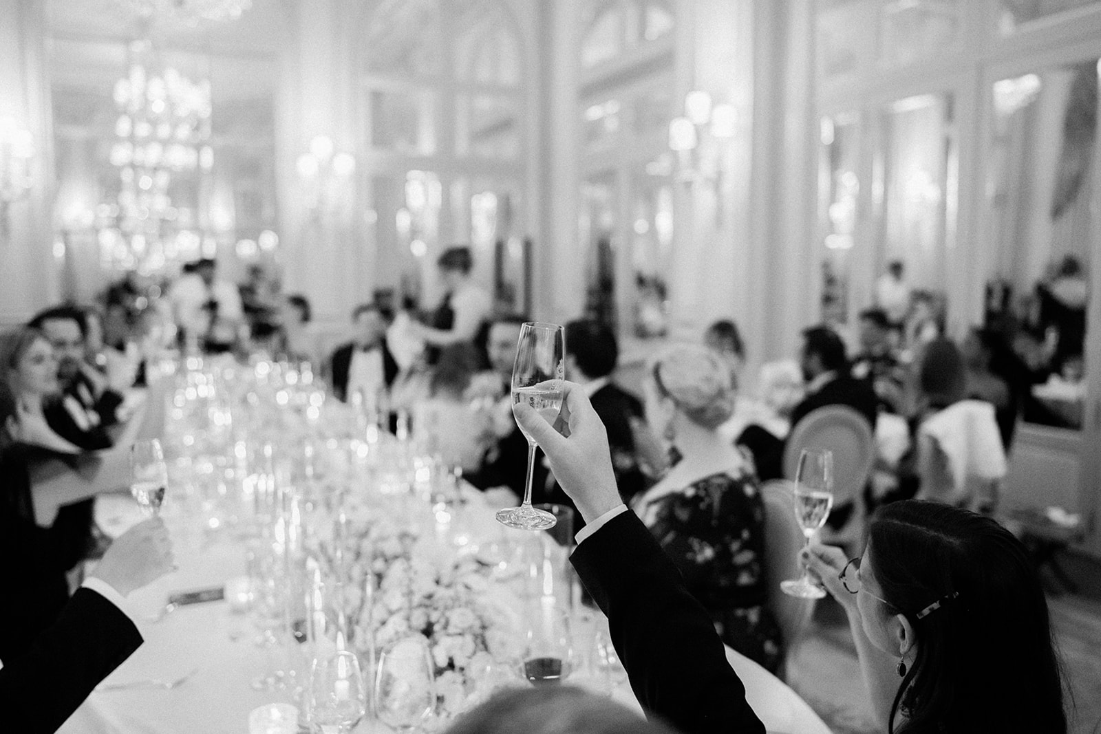 Editorial close-up of a champagne toast at a Paris wedding reception