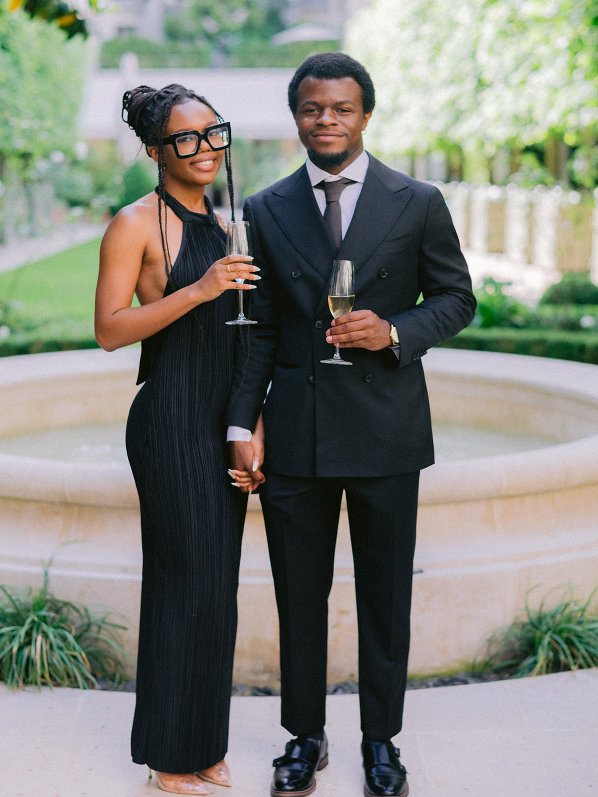 Fashionable wedding guests holding champagne during cocktail hour in Paris