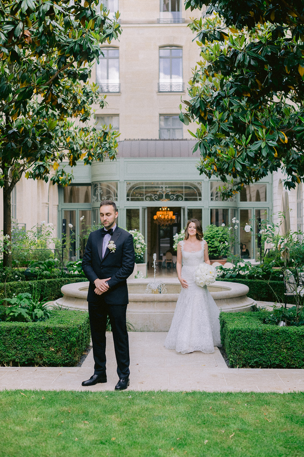 Bride approaching the groom for a first look in a private Paris garden