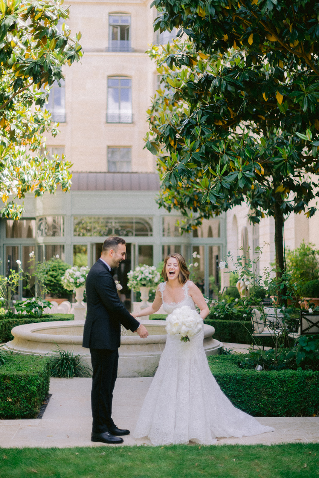 Bride and groom laughing during their first look at a luxury Paris wedding