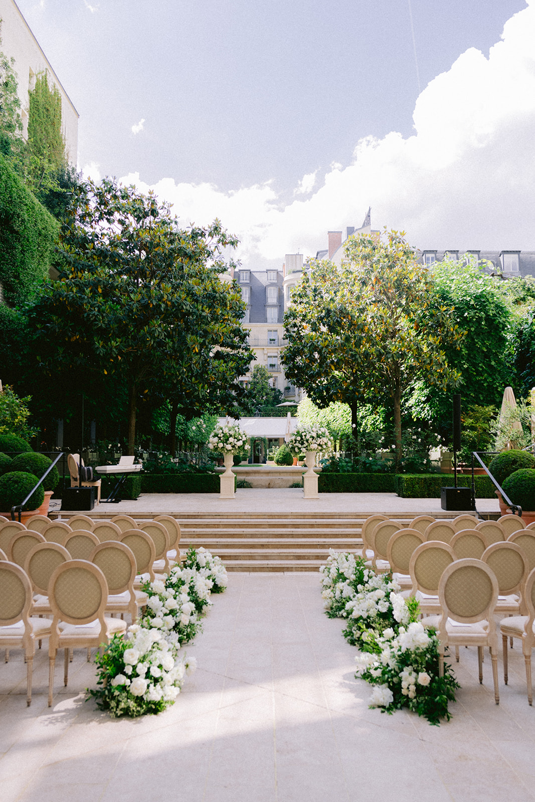 Luxury outdoor wedding ceremony with white flowers in a Paris garden