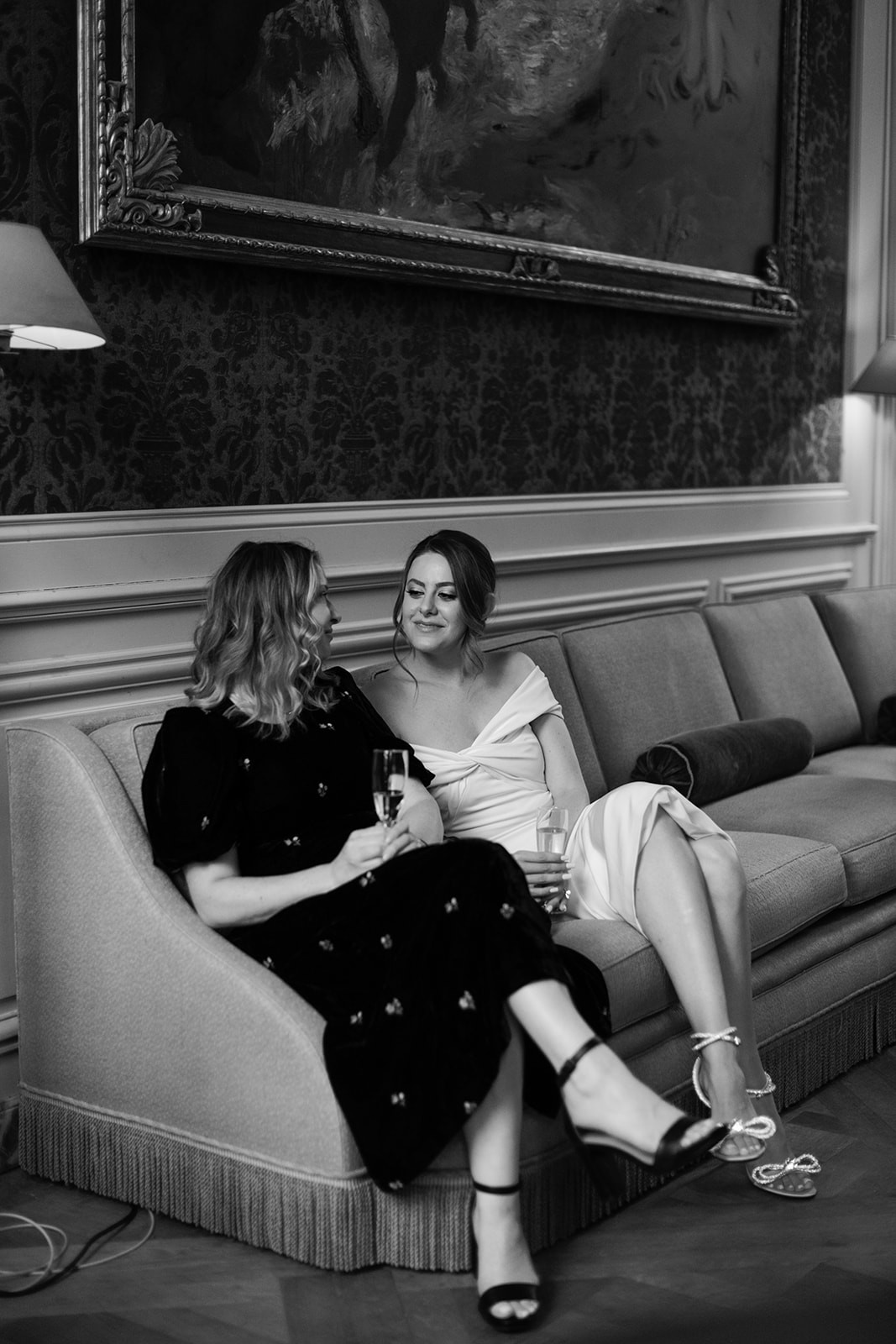 Black-and-white candid portrait of the bride-to-be and a friend during the welcome dinner