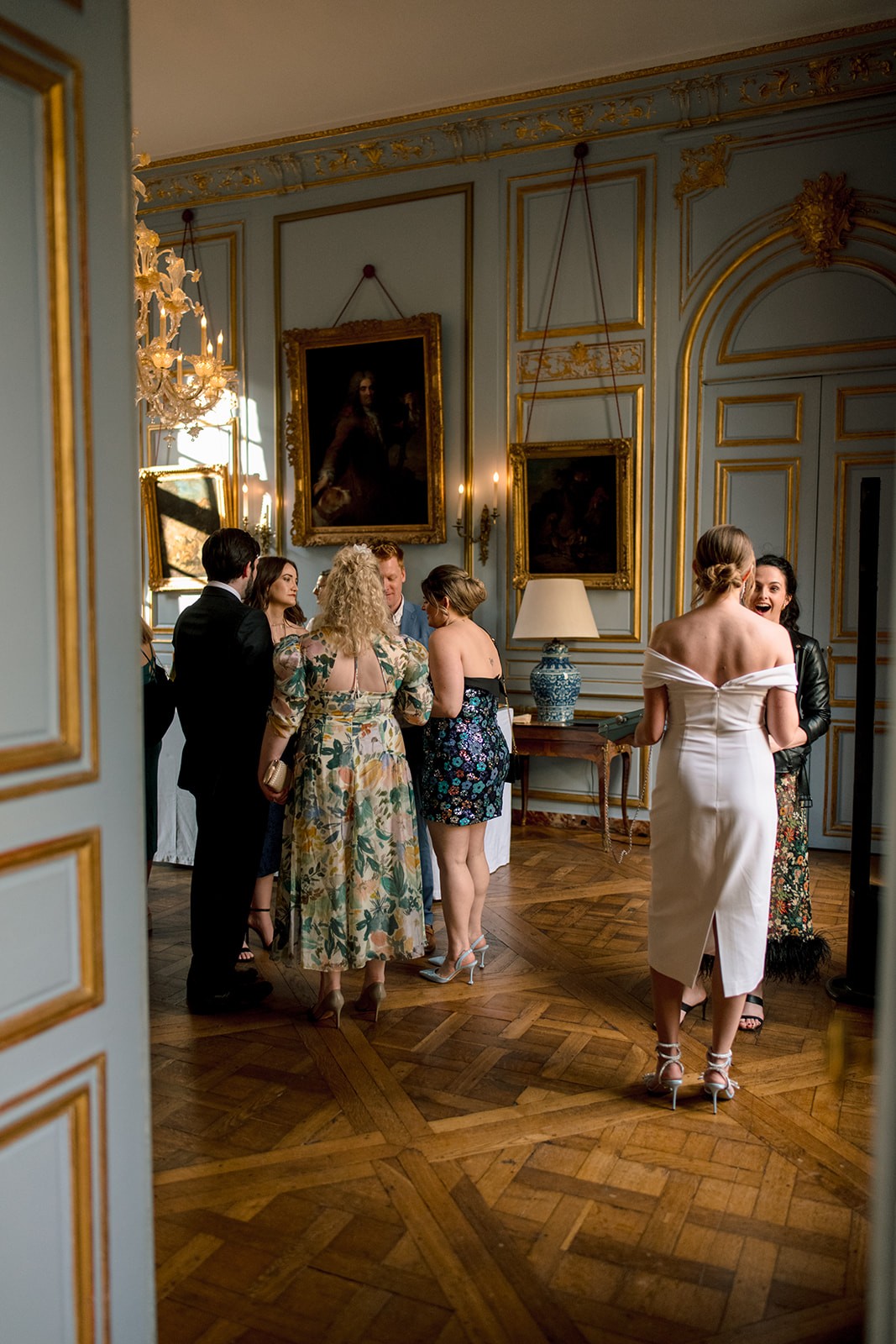 Wedding guests socializing in an elegant Paris salon during the welcome dinner