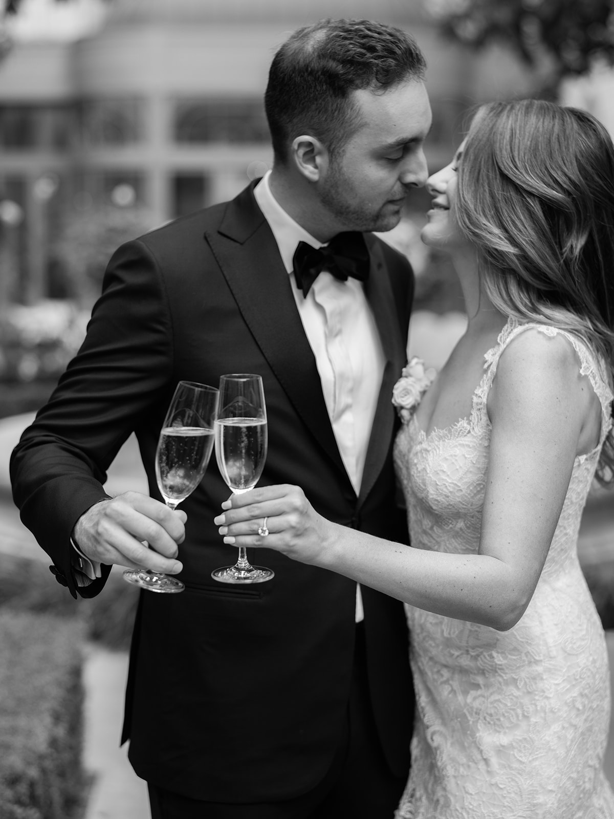 Black-and-white portrait of newlyweds sharing a champagne toast in Paris