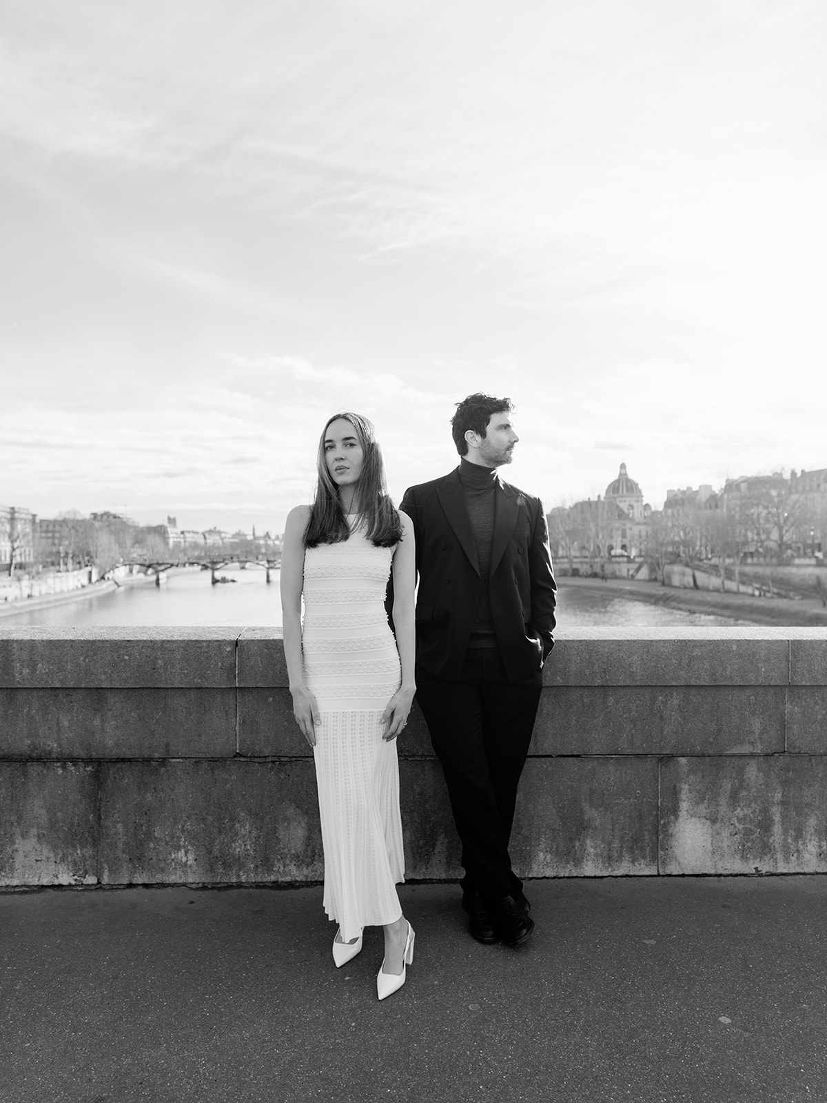Black-and-white editorial couple portrait overlooking the Seine and the Paris skyline