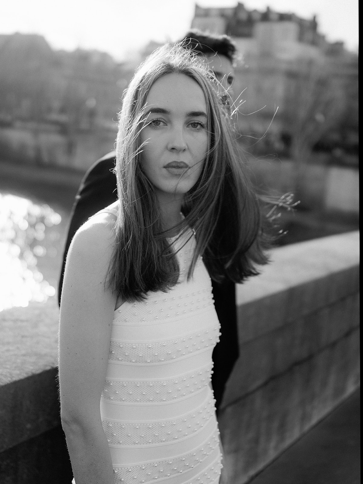 Black-and-white fashion portrait with wind and backlight beside the Seine