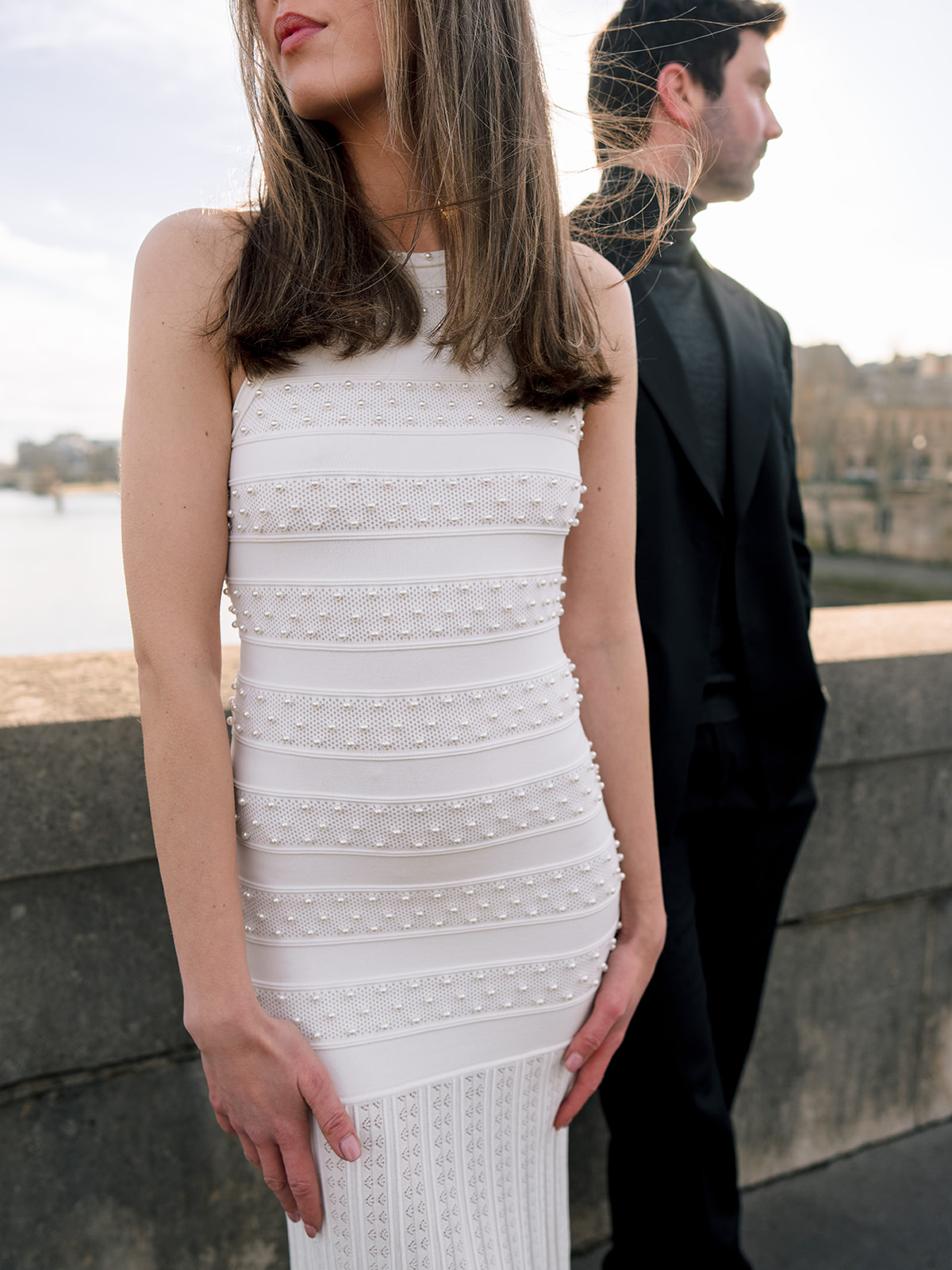 Fashion-forward couple portrait with a layered composition beside the Seine in Paris