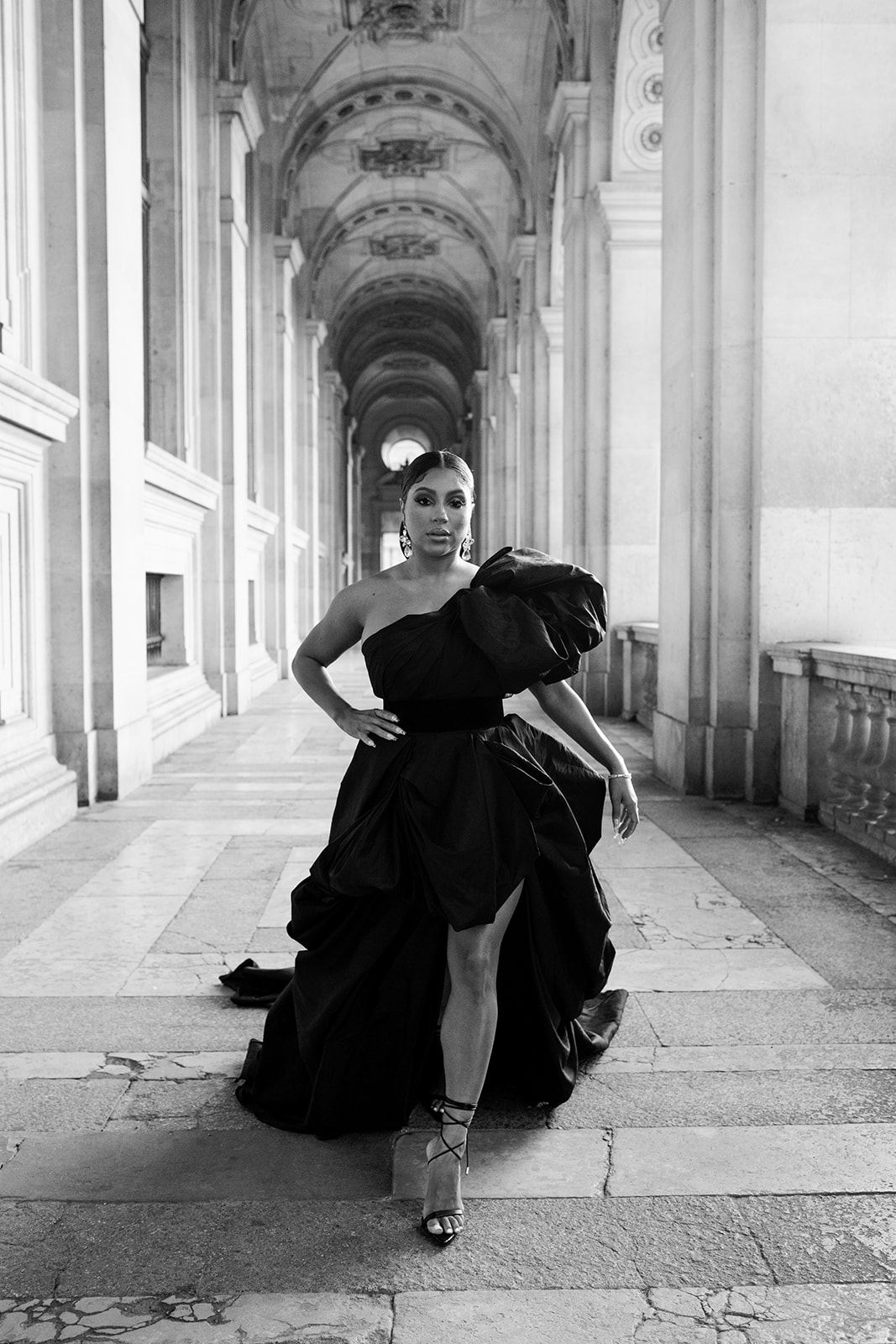 Candice Craig walking in a voluminous black editorial dress at the Louvre in Paris
