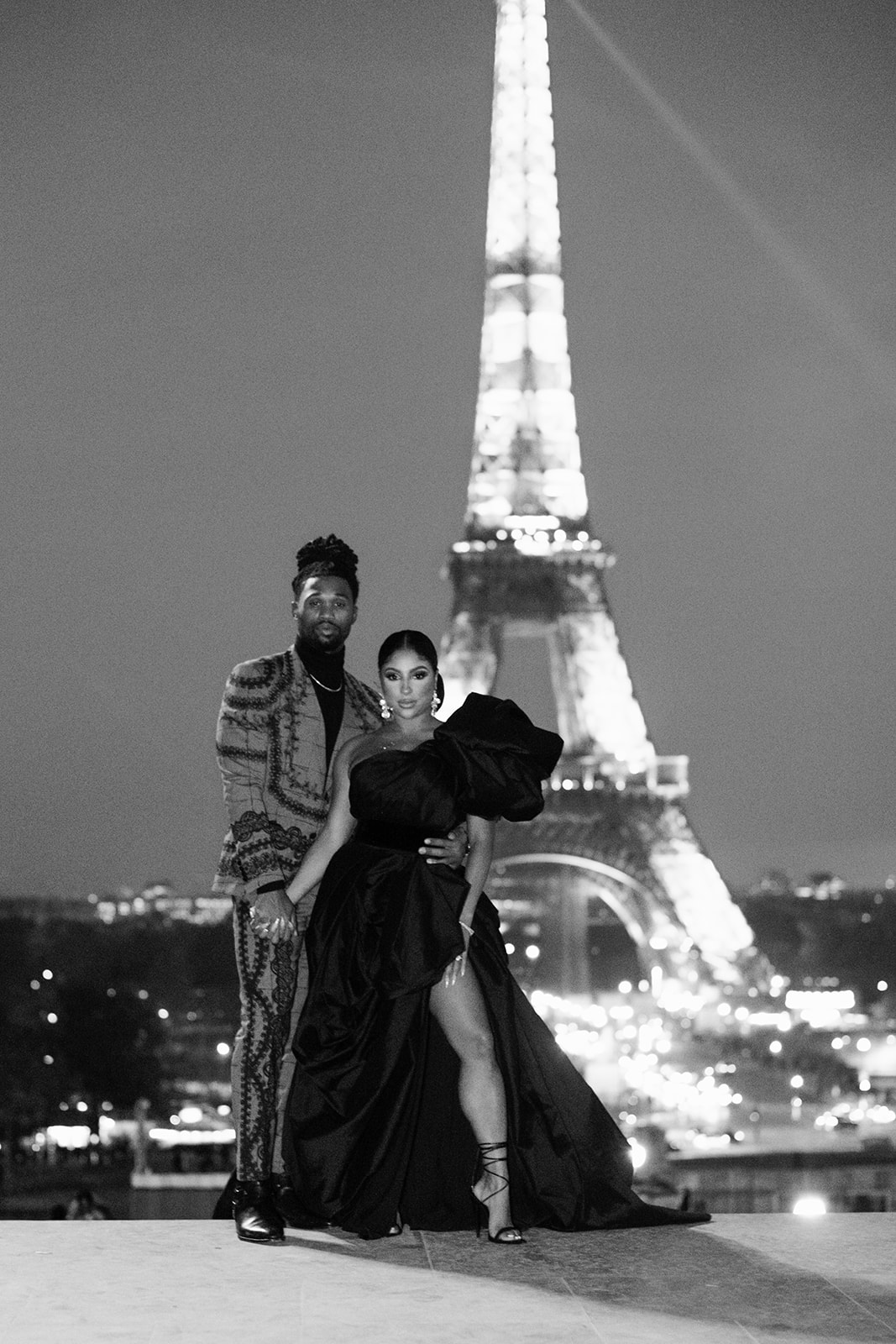Candice Craig and Omar Bolden photographed at night in front of the Eiffel Tower