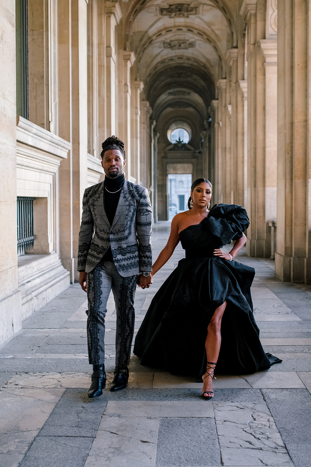 Candice Craig and Omar Bolden sharing a playful fashion moment at the Louvre in Paris