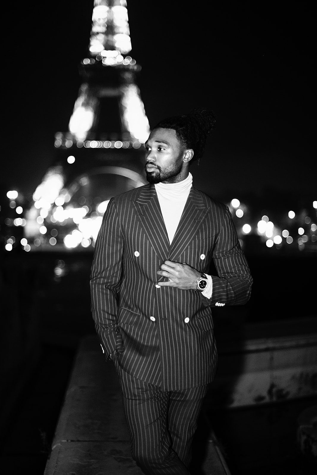 Black-and-white portrait of Omar Bolden at night with the Eiffel Tower in the background