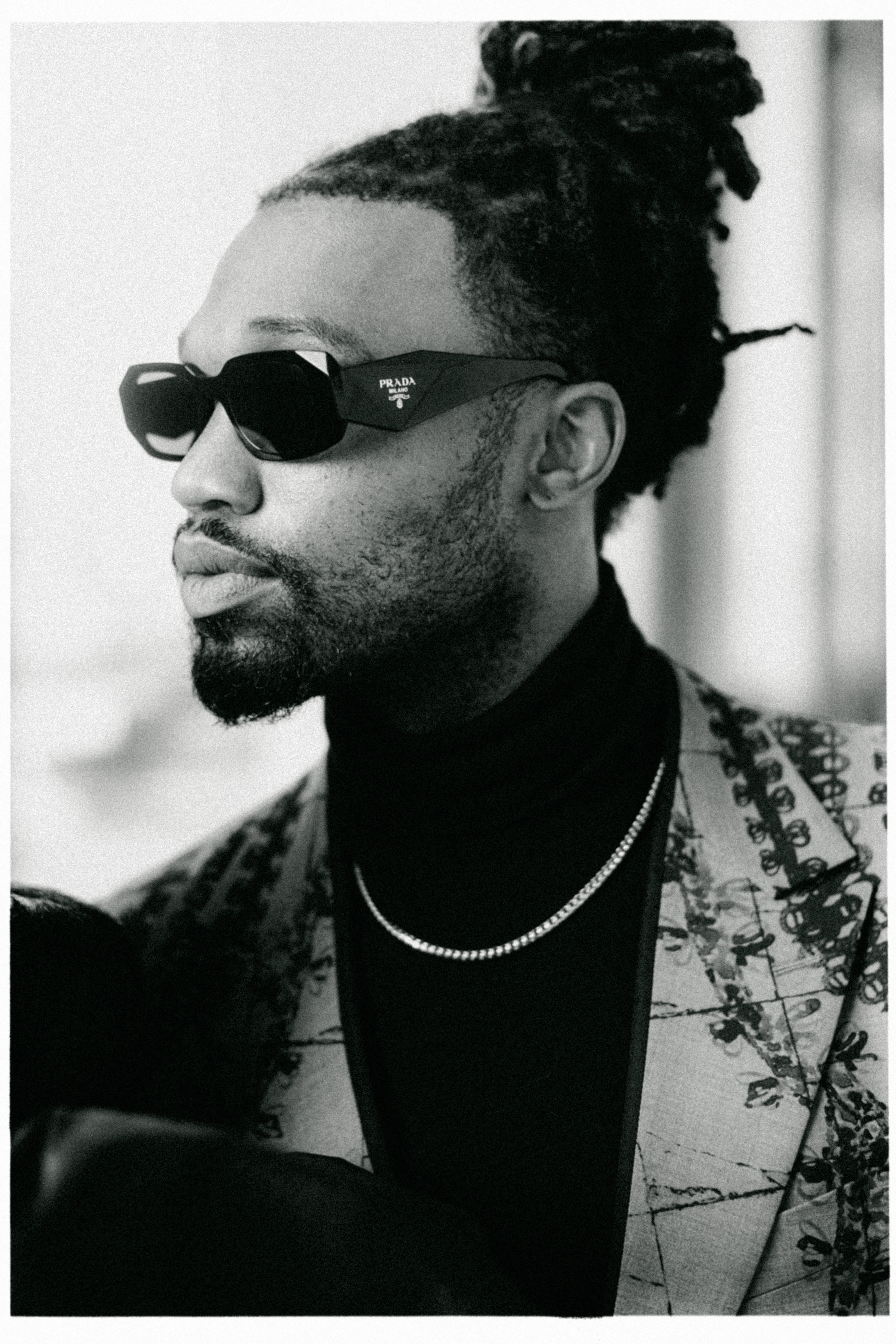 Black-and-white fashion portrait of Omar Bolden wearing sunglasses at the Louvre in Paris