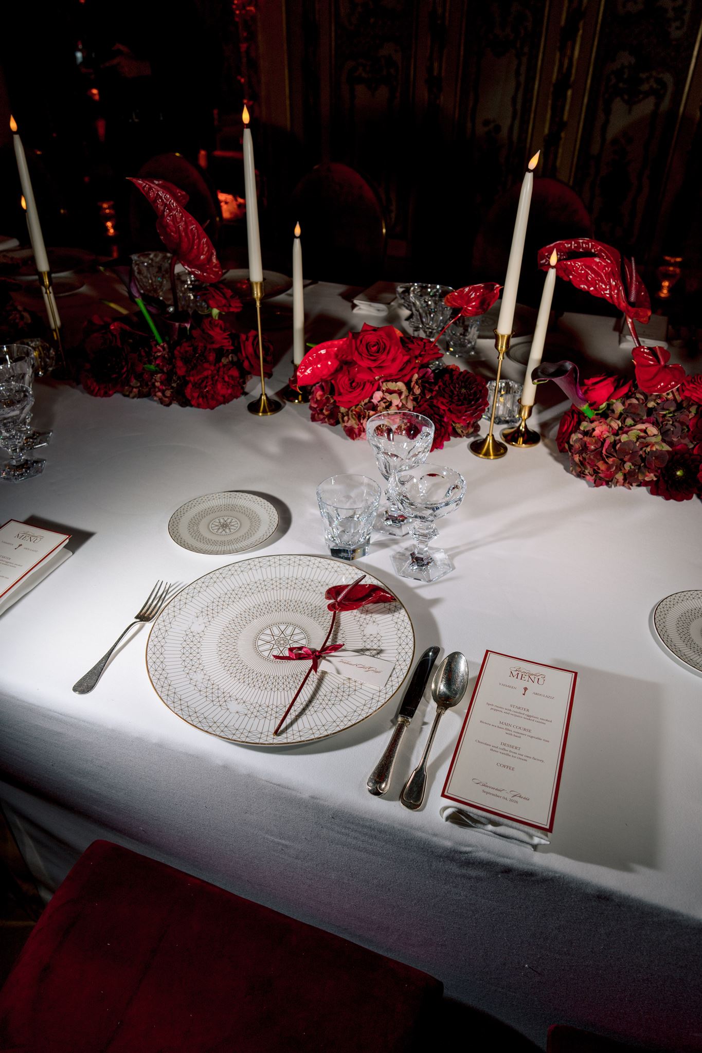 Long red floral reception table at Maison Baccarat in Paris