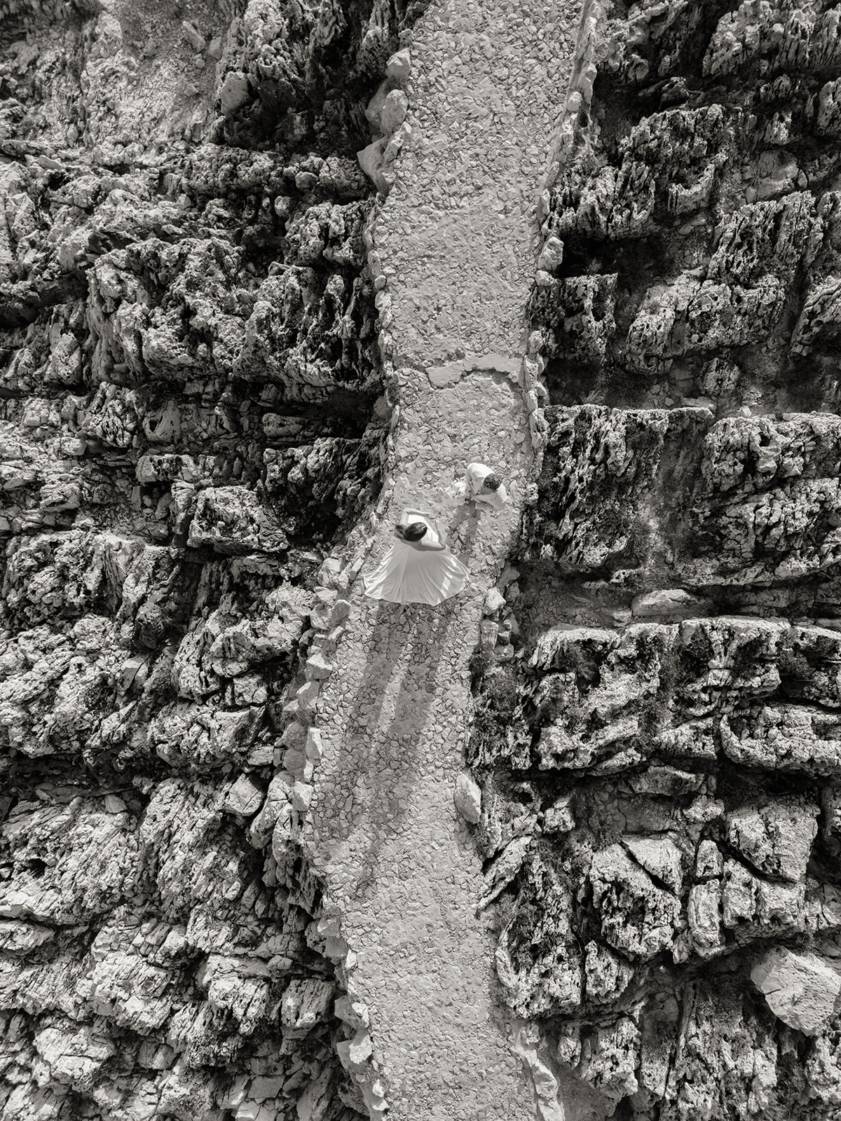 Black-and-white aerial wedding portrait on the rocky coastline of Saint-Jean-Cap-Ferrat