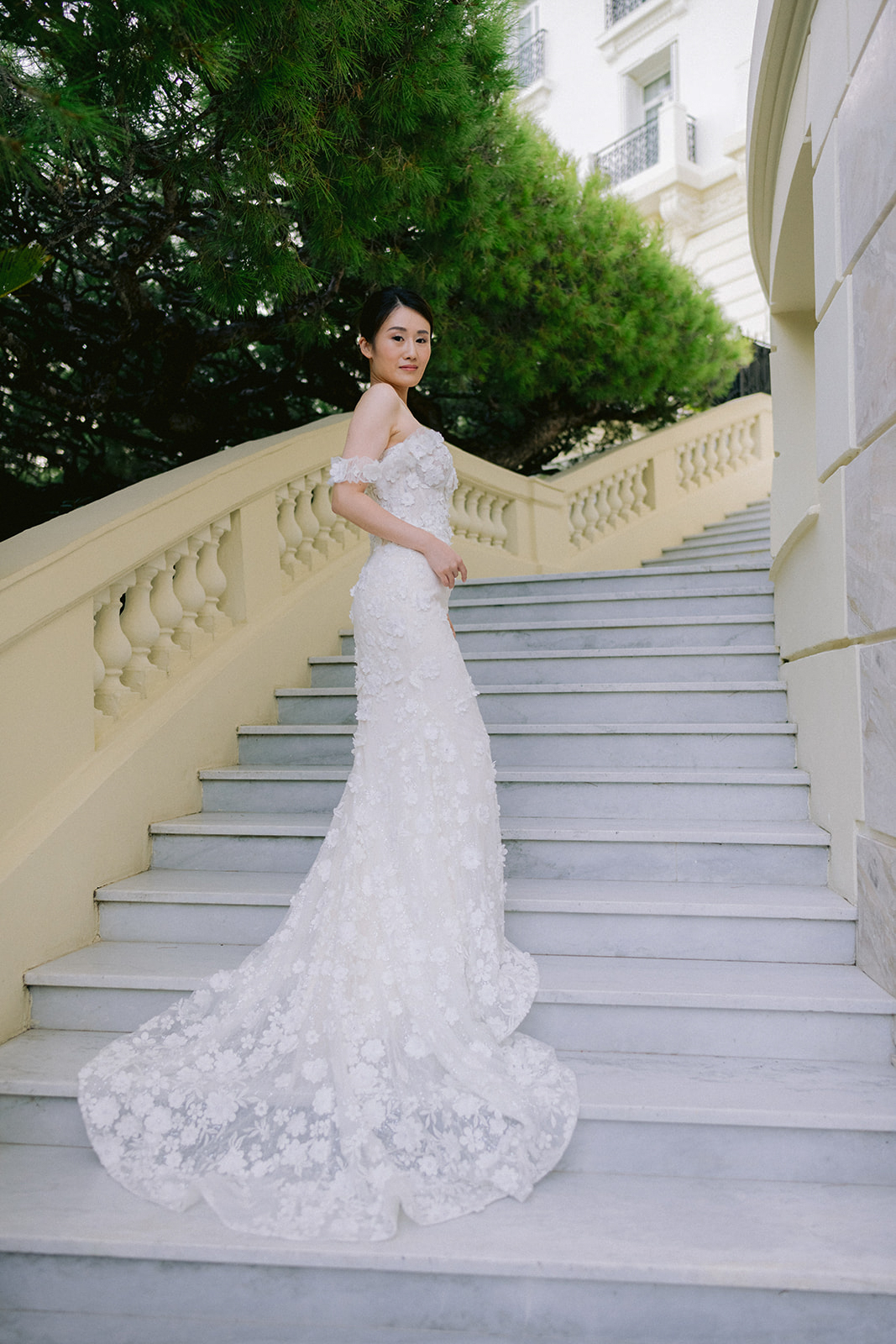 Bride in a floral gown on the exterior staircase of Four Seasons Cap-Ferrat