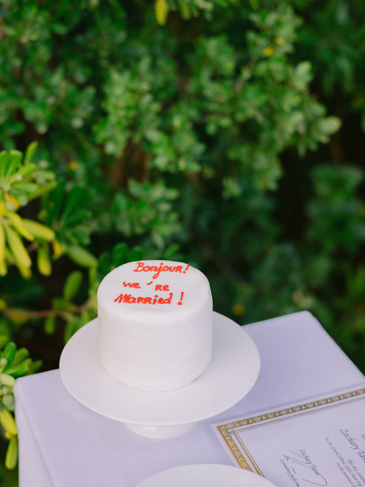 Modern white wedding cake reading Bonjour we are married