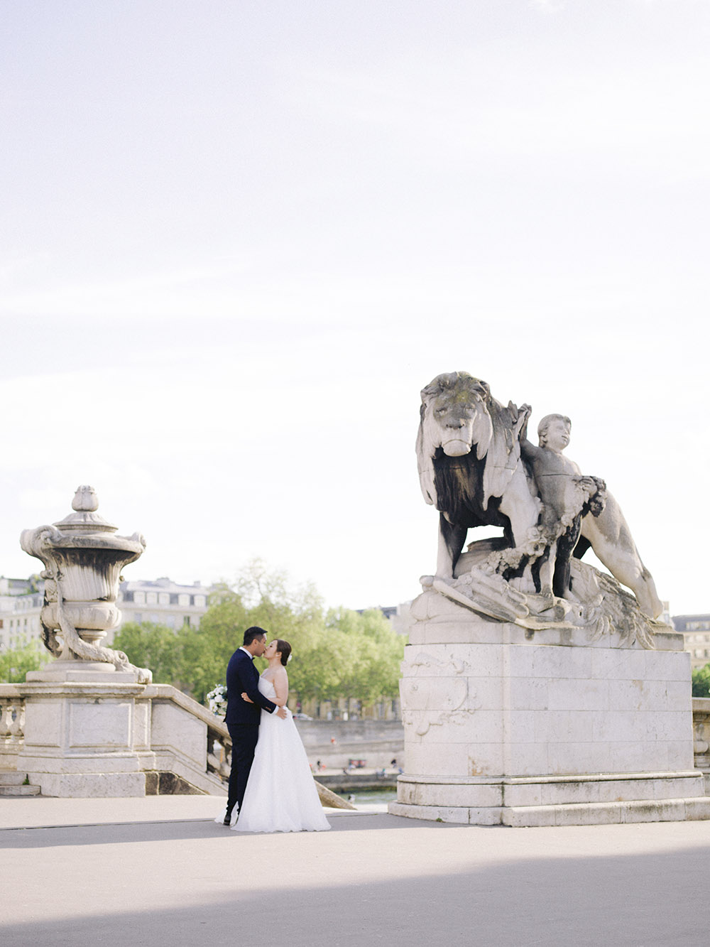 des mariées se prennent dans les bras on y voit une magnique statue du pont alexandre 3