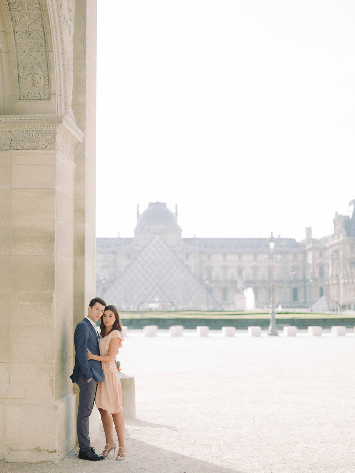 un couple s embrasse a coté des pyramide du louvre il fait nuit
