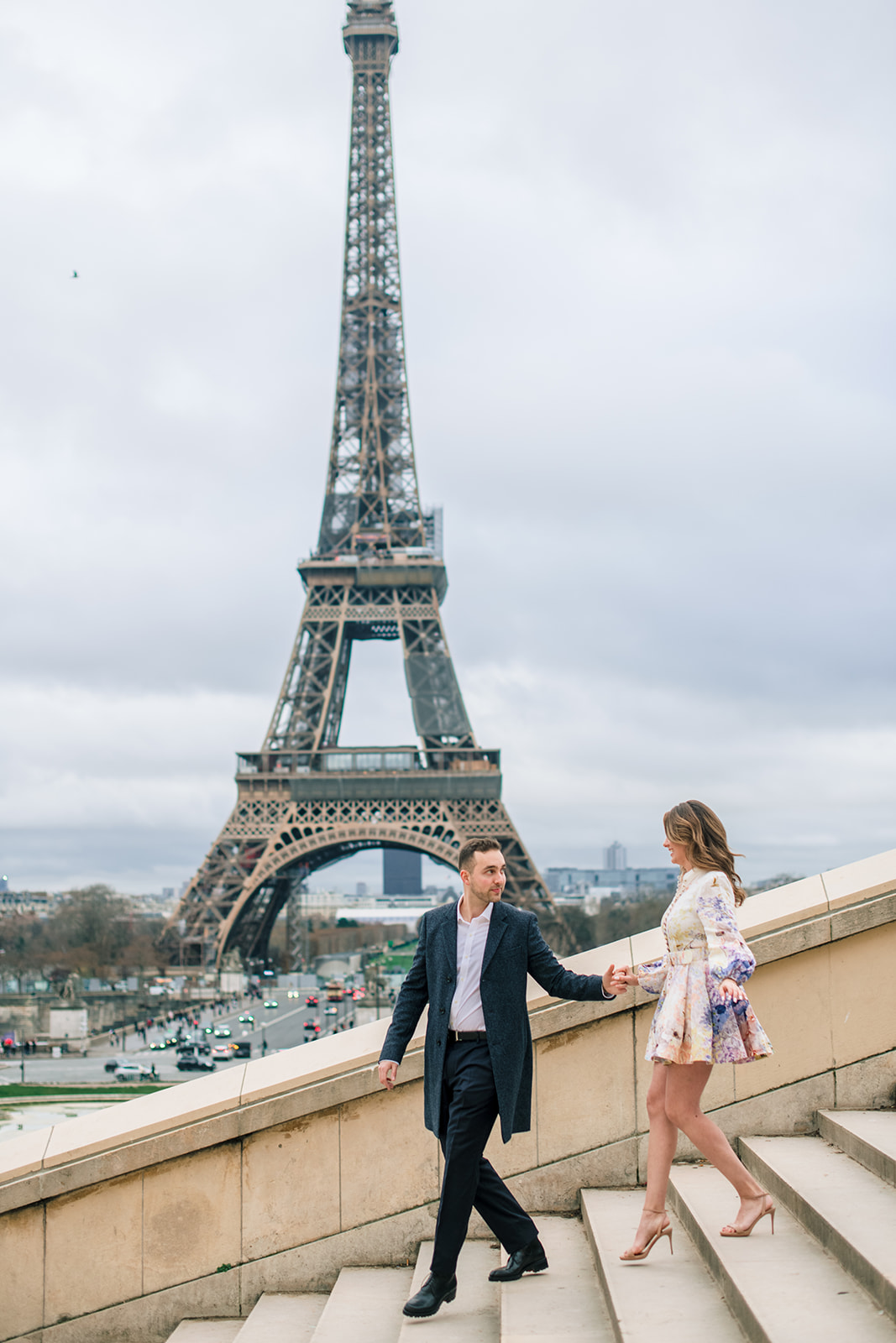 Couple walking down the Trocadéro steps with the Eiffel Tower behind them
