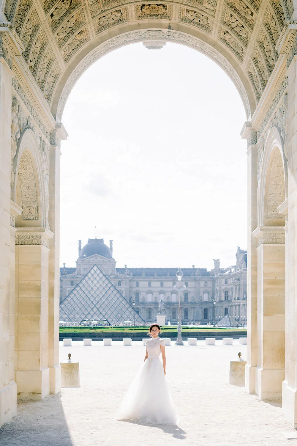 Bride beneath an arch at the Louvre during a Paris portrait session