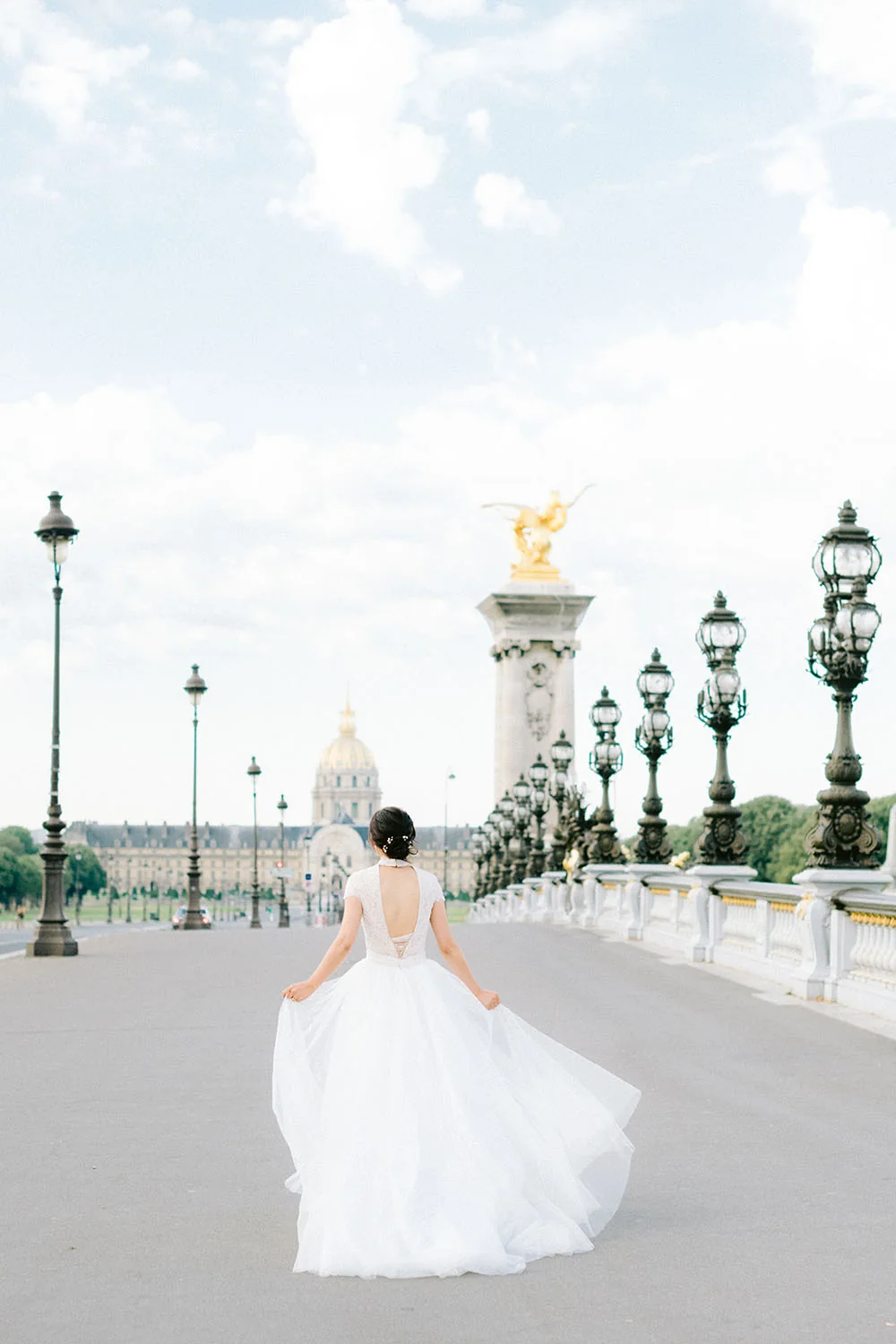 Bride running across Pont Alexandre III in an Ersa Atelier wedding dress