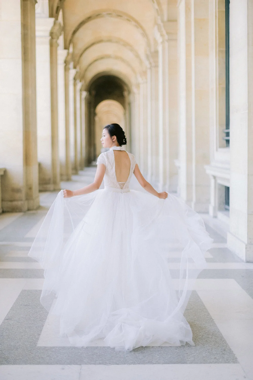 Bride running through the Louvre courtyard in Paris