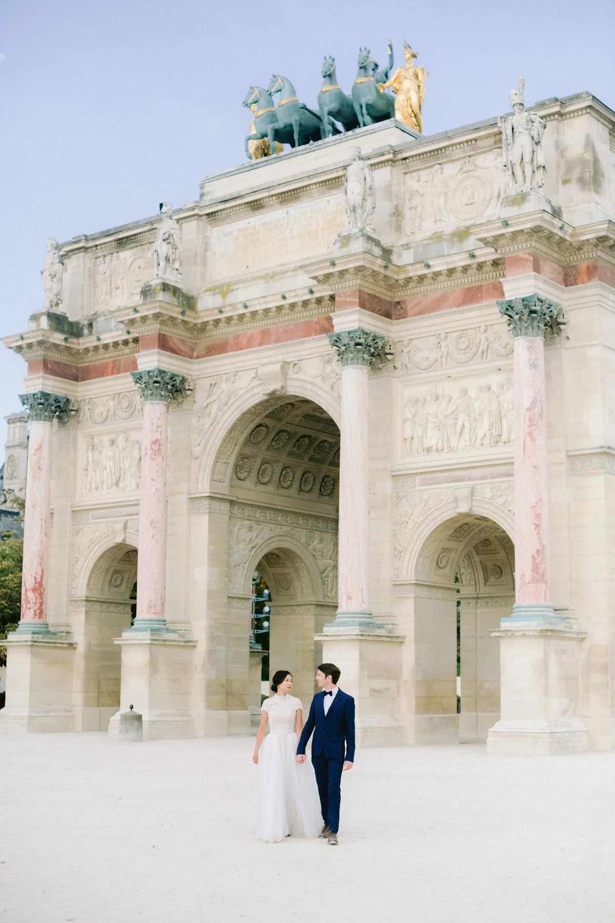 Couple beneath the monumental architecture of Petit Palais during their Paris pre-wedding session