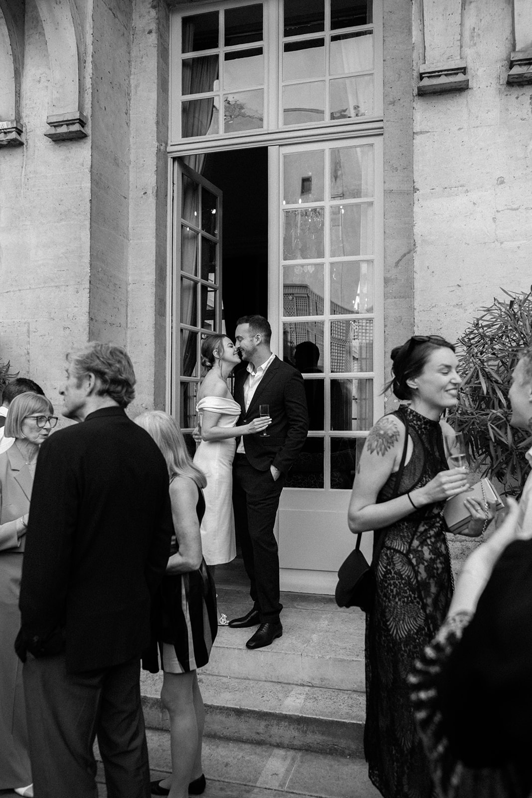 Couple &eacute;changeant un baiser pendant le d&icirc;ner de bienvenue avant leur mariage au Ritz Paris