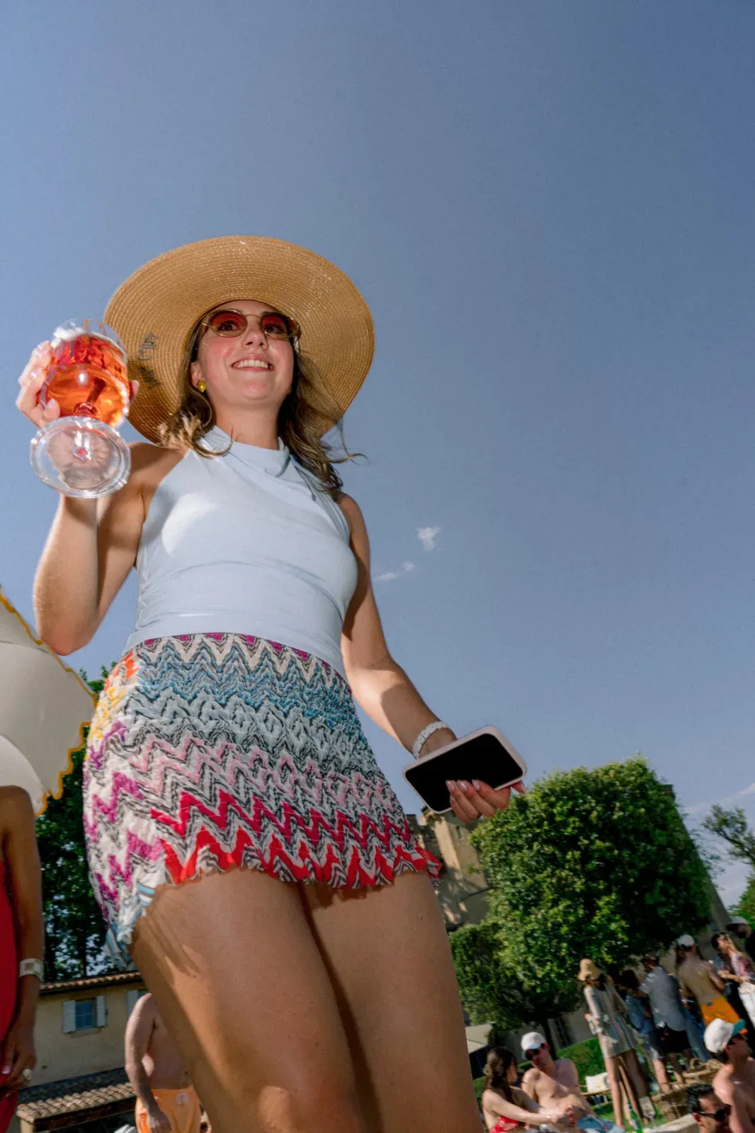Guest with a summer drink during the Day 1 pool party at Villa Baulieu in Provence