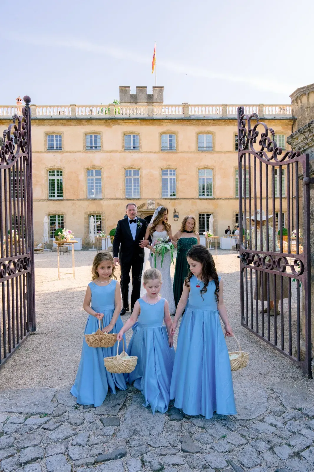 Flower girls entering through the gates of Villa Baulieu before the wedding ceremony
