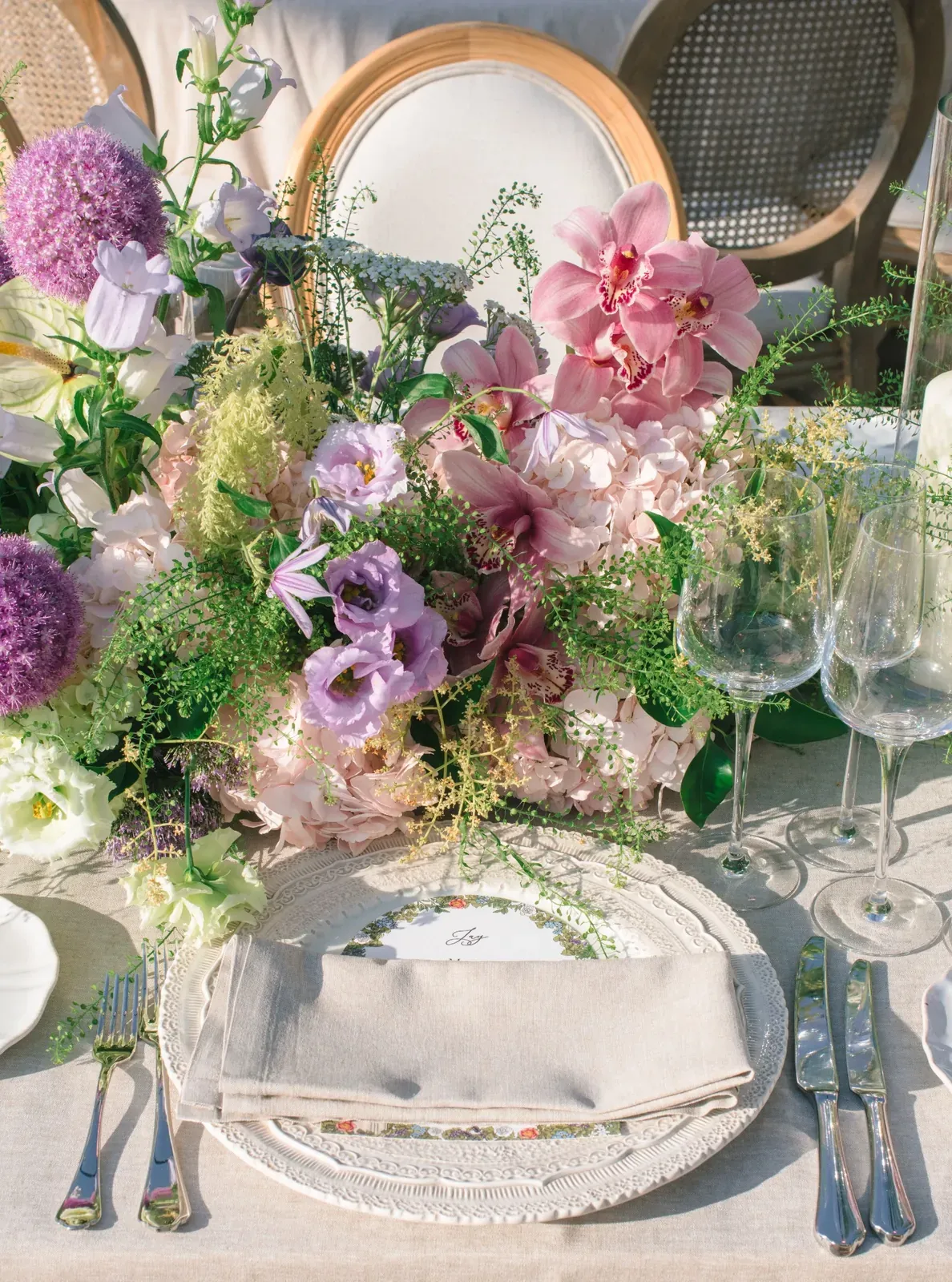 Wedding table setting with orchids and pastel floral design at Villa Baulieu