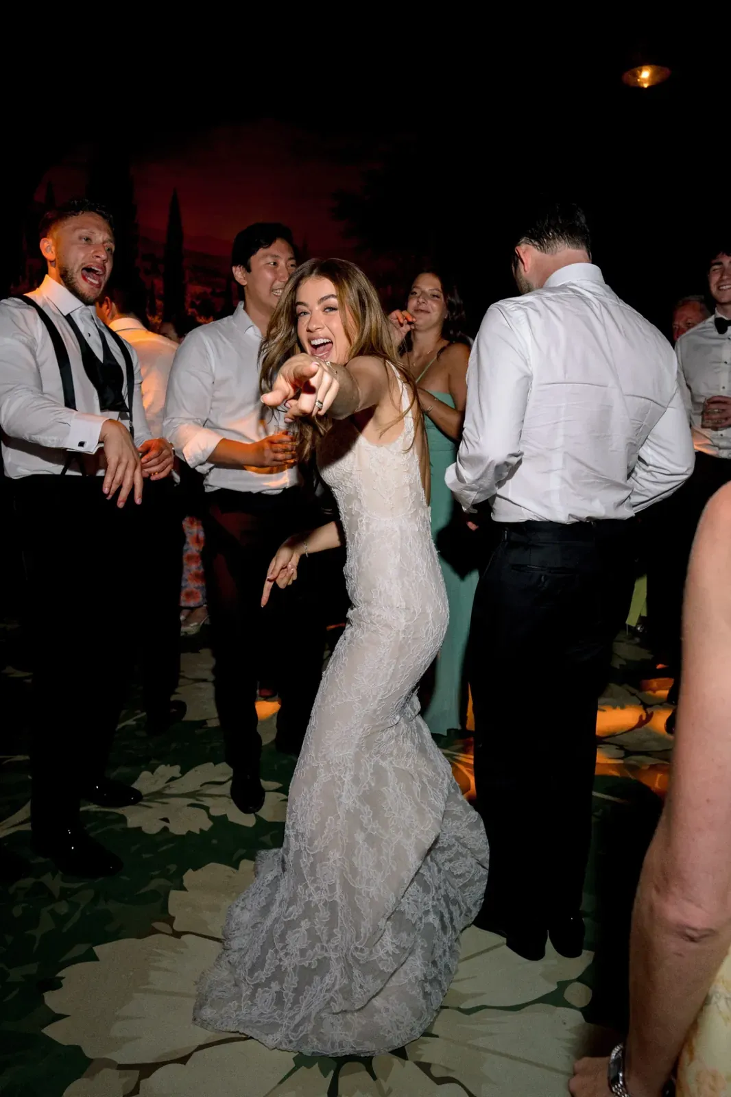 Bride pointing toward the camera on the Villa Baulieu wedding day celebration dance floor