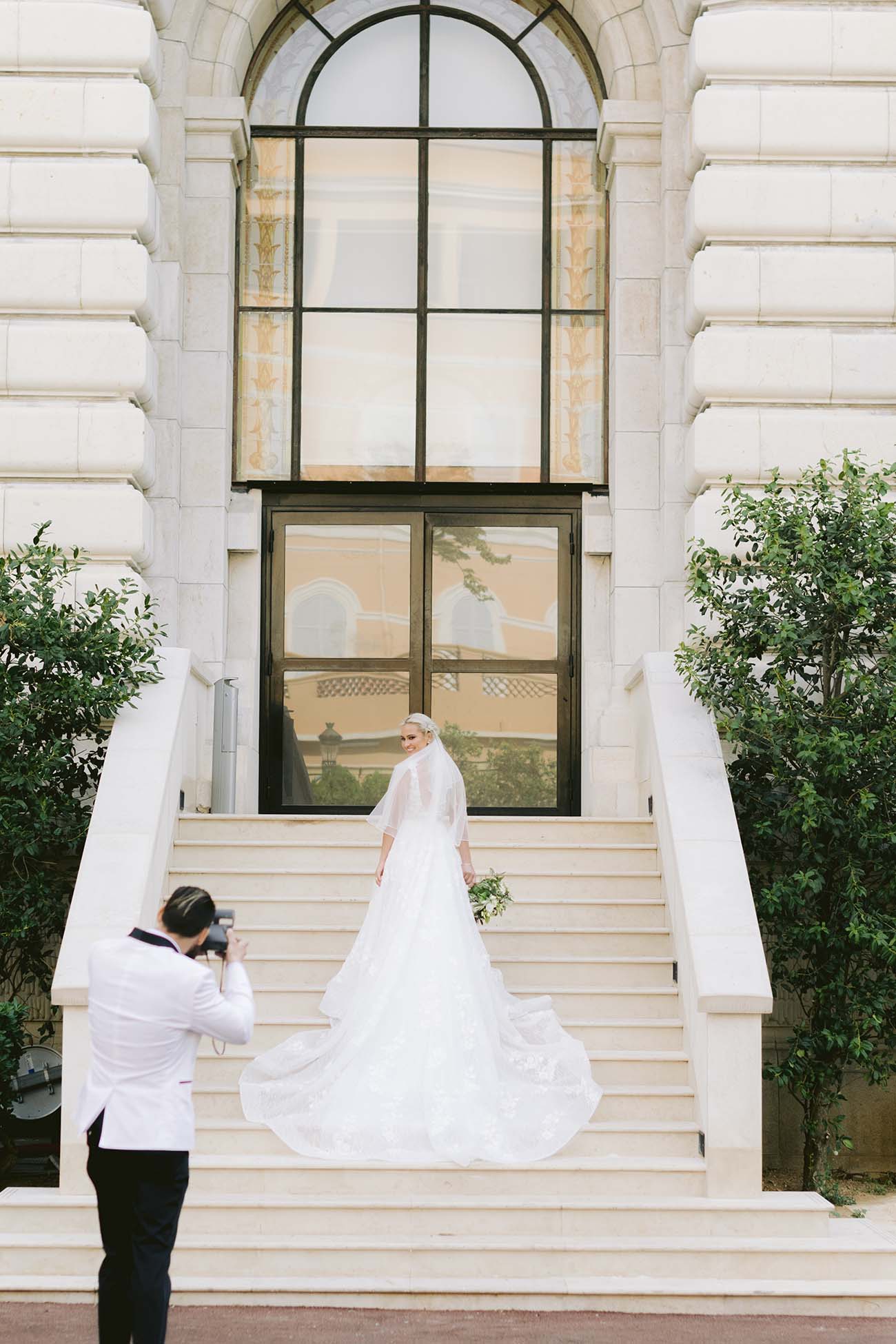 le marié prend sa femme en photo sur les marche du musé de monaco
