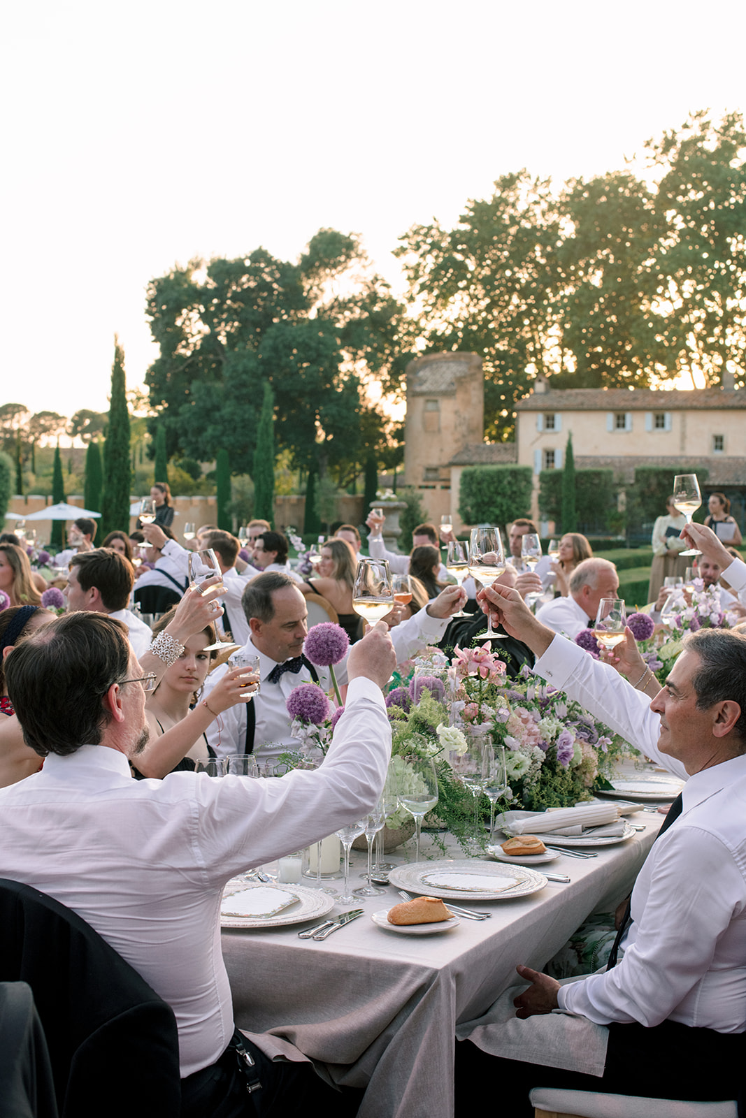 Guests raising a toast during an outdoor wedding reception at Villa Baulieu in Provence