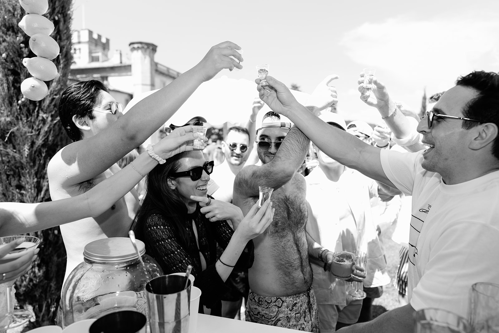 Wedding guests sharing a tequila toast in black and white at Villa Baulieu