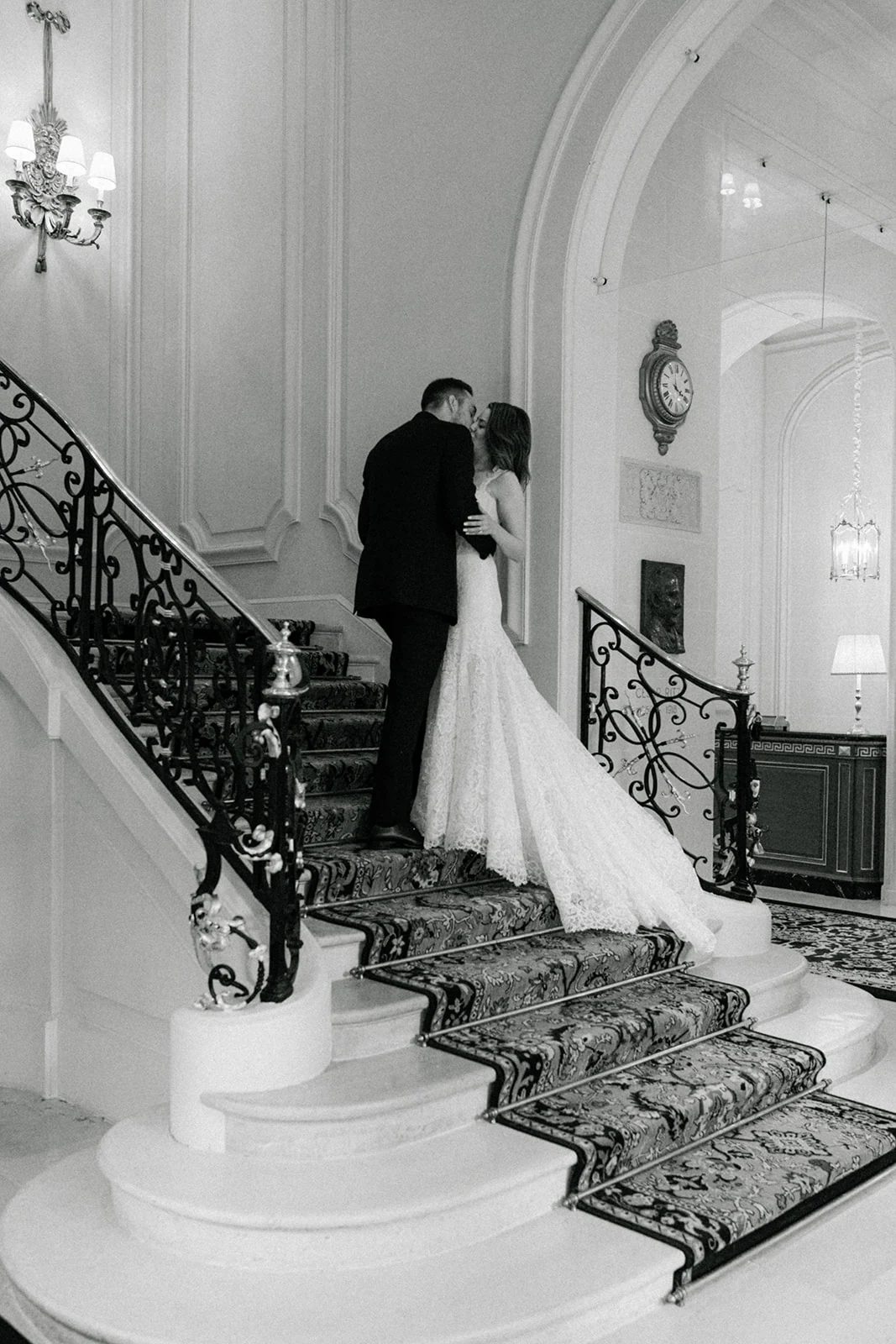 Black-and-white portrait of the bride and groom on the Ritz Paris staircase