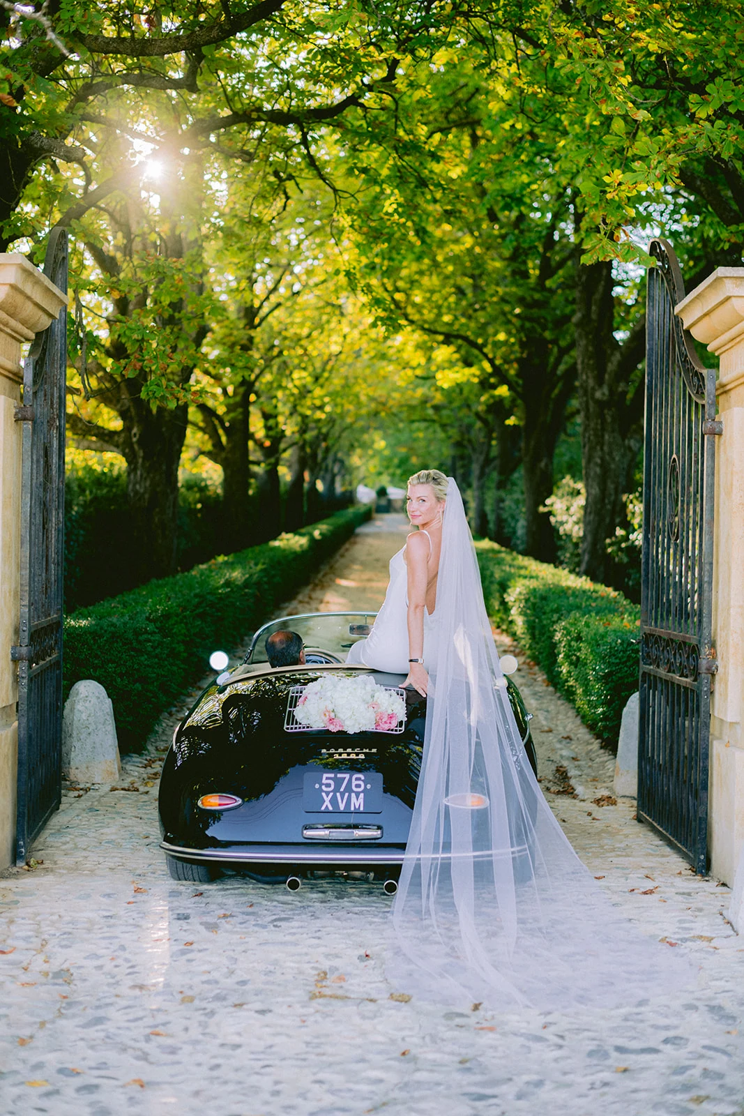 Bride posing with a classic car at Château de la Gaude