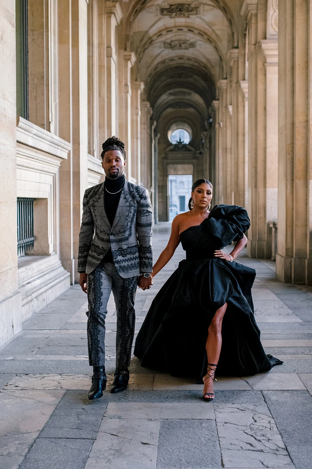 Candice Craig and Omar Bolden sharing a playful fashion moment at the Louvre in Paris
